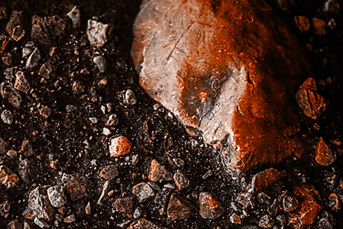 Alien Skull Rock Face Emerging Atop Dirt Surface (Orange Tone Photo)