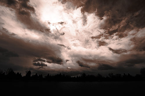 Clouds Spiraling Above Dark Lit Lake (Orange Tone Photo)