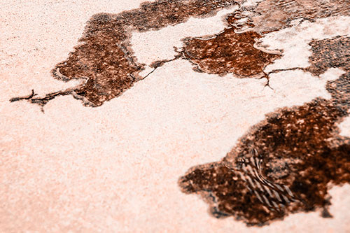 Creeping Water Puddle Across Concrete Pavement (Orange Tone)
