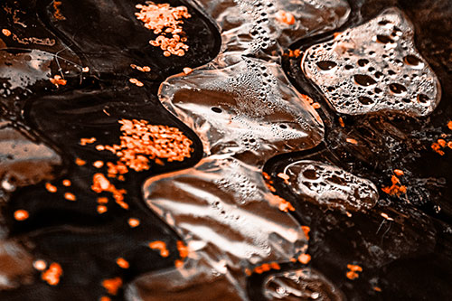 Distorted Plastic Bubble Face Floating Atop Water (Orange Tone)