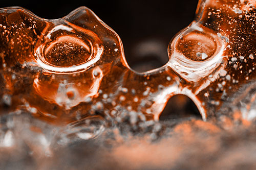Vertical Bubble Eyed Screaming Ice Face Along Frozen River (Orange Tone Photo)
