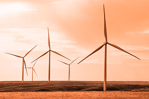 Wind Turbines Standing Tall On Green Pasture (Orange Tone Photo)