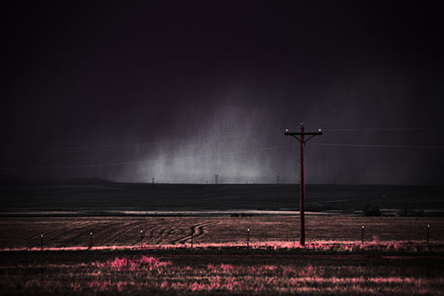 Distant Thunderstorm Rains Down Upon Powerlines (Pink Tint Photo)