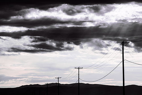 Powerline Silhouette Entering Mountain Range (Pink Tint Photo)
