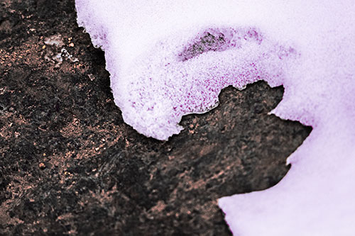 Screaming Snow Face Slowly Melting Atop Rock Surface (Pink Tint Photo)