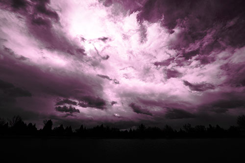 Clouds Spiraling Above Dark Lit Lake (Pink Tone Photo)