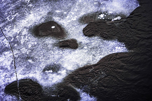 Disintegrating Ice Face Melting Among Flowing River Water (Purple Tint Photo)