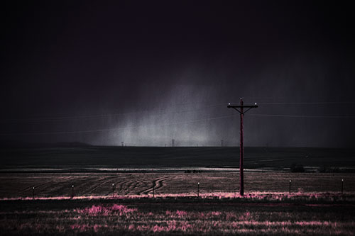 Distant Thunderstorm Rains Down Upon Powerlines (Purple Tint Photo)