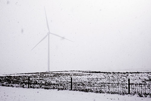 Fenced Wind Turbine Among Blowing Snow (Purple Tint Photo)