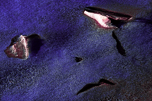 Sad Teardrop Ice Face Appears Atop Frozen River (Purple Tint Photo)