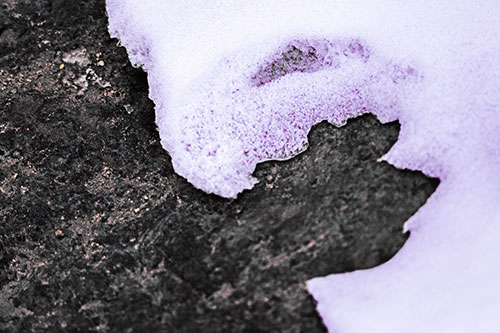 Screaming Snow Face Slowly Melting Atop Rock Surface (Purple Tint Photo)