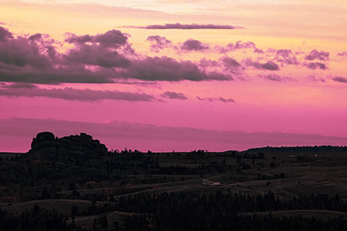 Sunrise Over Rock Formations On The Horizon (Purple Tint Photo)