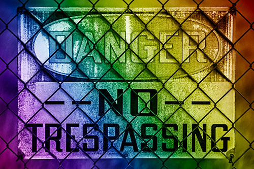 Dirty Danger No Trespassing Sign Behind Chain Link Fence (Rainbow Shade)