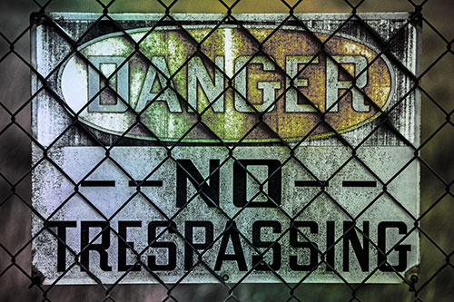 Dirty Danger No Trespassing Sign Behind Chain Link Fence (Rainbow Tint)