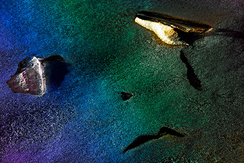 Sad Teardrop Ice Face Appears Atop Frozen River (Rainbow Tint Photo)