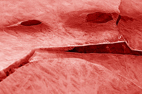 Rock Face Emerges Among Cracked Frozen Ice (Red Shade)