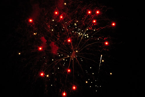 Firework Light Orbs Free Falling After Explosion (Red Tint Photo)