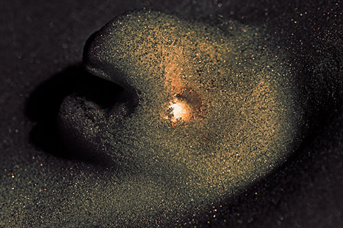 Glowing Eyed Snow Face Emerges Above Soil (Red Tint)