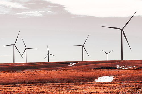 Wind Turbines Scattered Around Melting Snow Patches (Red Tint Photo)
