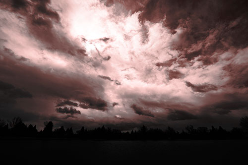 Clouds Spiraling Above Dark Lit Lake (Red Tone Photo)