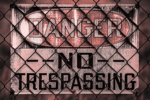 Dirty Danger No Trespassing Sign Behind Chain Link Fence (Red Tone)