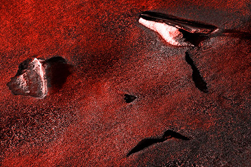 Sad Teardrop Ice Face Appears Atop Frozen River (Red Tone)