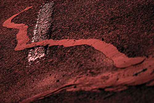 Slithering Tar Creeps Over Pavement Marking (Red Tone Photo)