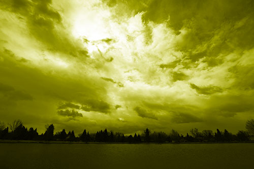 Clouds Spiraling Above Dark Lit Lake (Yellow Shade Photo)