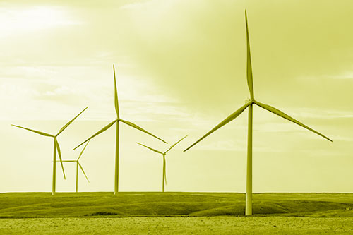 Wind Turbines Standing Tall On Green Pasture (Yellow Shade Photo)