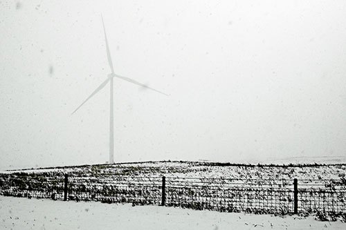 Fenced Wind Turbine Among Blowing Snow (Yellow Tint Photo)