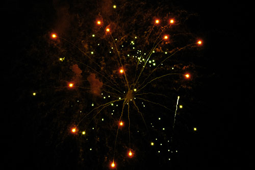 Firework Light Orbs Free Falling After Explosion (Yellow Tint Photo)