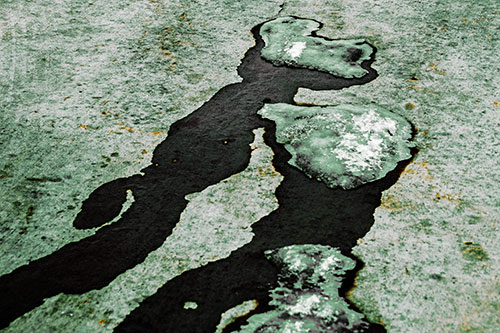 Melting Ice Puddles Forming Water Streams (Yellow Tint Photo)