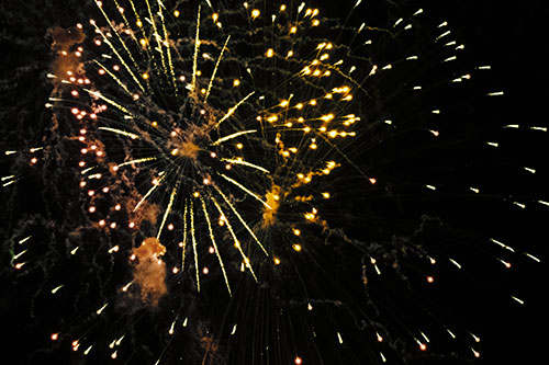 Multiple Firework Explosions Send Light Orbs Flying (Yellow Tint Photo)