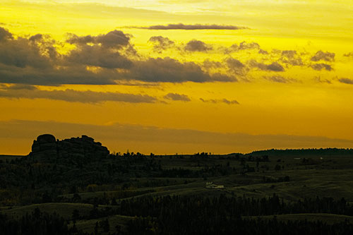 Sunrise Over Rock Formations On The Horizon (Yellow Tint Photo)