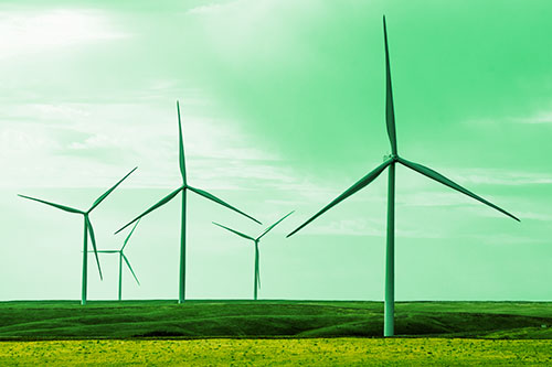 Wind Turbines Standing Tall On Green Pasture (Yellow Tint Photo)