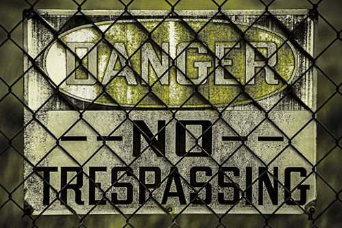 Dirty Danger No Trespassing Sign Behind Chain Link Fence (Yellow Tone)
