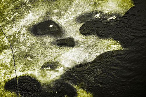 Disintegrating Ice Face Melting Among Flowing River Water (Yellow Tone Photo)