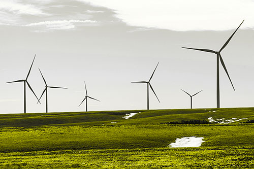 Wind Turbines Scattered Around Melting Snow Patches (Yellow Tone Photo)
