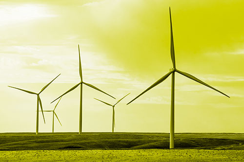 Wind Turbines Standing Tall On Green Pasture (Yellow Tone Photo)